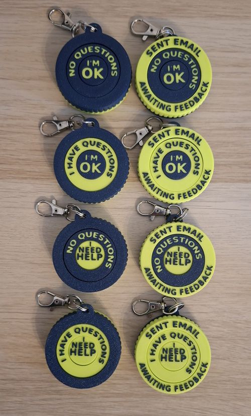A series of round fidget toys. They can be turned to show messages such as I'm ok or I need help. I have questions. Or sent email